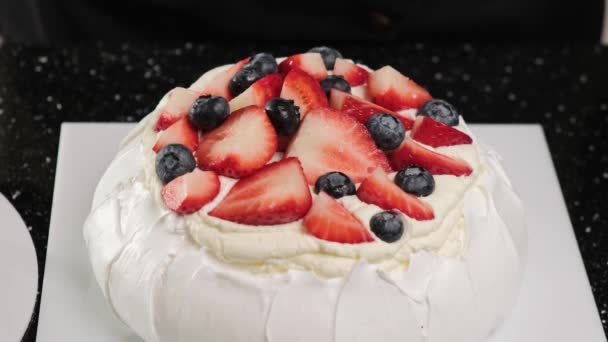 Chef de pastelaria decora bolo Anna Pavlovas com frutas frescas e folhas de hortelã. — Vídeo de Stock