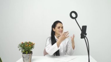 Nutritionist iş yerinde cep telefonu kullanarak görüntülü konuşma yapıyor, online danışma.