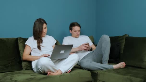Trabalho em família de casa, mulher usando um laptop e homem usando um smatphone. — Vídeo de Stock