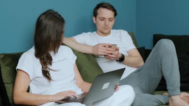 Praca rodzinna z domu, kobieta korzystająca z laptopa i mężczyzna korzystający ze smartfona. — Wideo stockowe