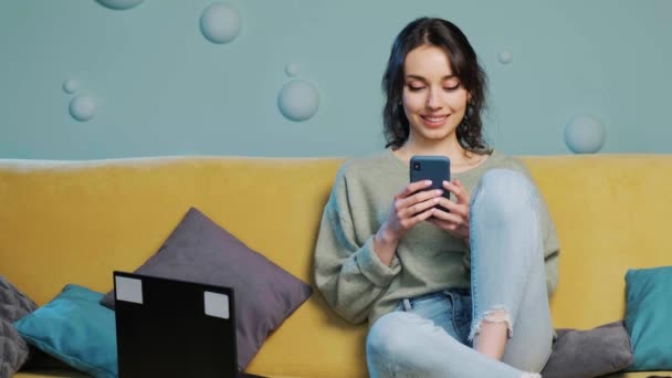 Mujer sosteniendo el teléfono inteligente y viendo un video divertido, chating en las redes sociales. — Vídeos de Stock