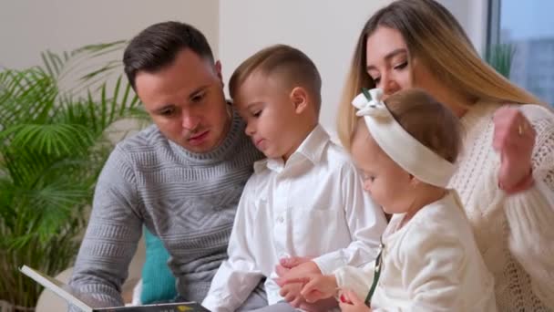 Adorável família, pai lendo um livro para sua família sentado na sala de estar. — Vídeo de Stock