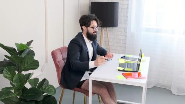Baard man comfortabel aan zijn bureau, met een video call conferentie. — Stockvideo