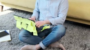 Bilgisayarın başında bir sürü hatırlatma notuyla çalışan adam, kanepenin yanında oturuyor..