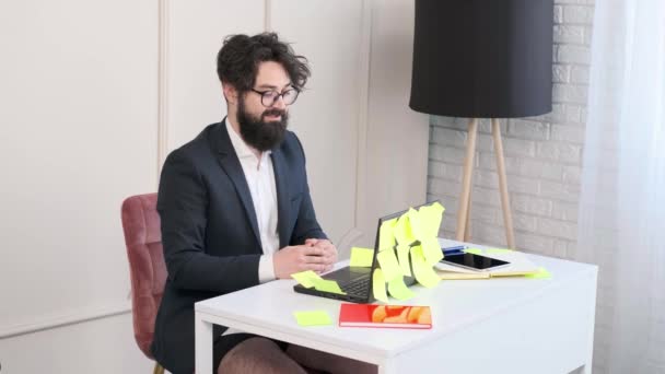 Bearded man comfortable at his desk, in underwear and jacket working remote. — Stock Video