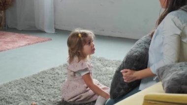 Anne küçük kızıyla oynar, ona sarılır ve öper..