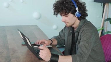 Genç adam evde bilgisayar kullanarak online alışveriş yapıyor..