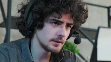 Laptop ve mikrofonlu yardım hattı çalışanı, kıvırcık saçlı adam..