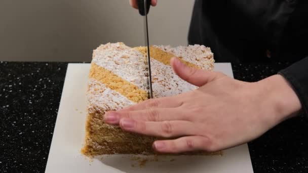De banketbakker snijdt de napoleon cake in twee gelijke stukken. — Stockvideo