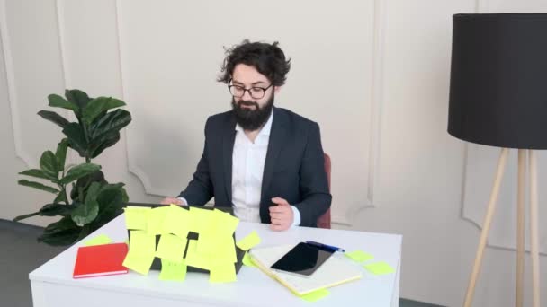 彼の机で快適な髭の男は、ビデオ通話会議を持っている. — ストック動画