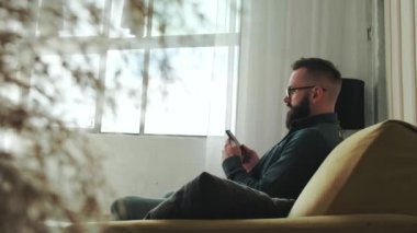 Evde boş günün tadını çıkarıyorum. Cep telefonuyla konuşan neşeli sakallı genç adam..