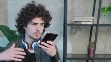 Adam ofisteki masada oturur ve akıllı telefondan hoparlörle konuşur..