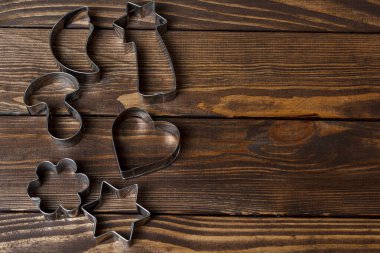 Kurabiye keskisi. Evde yemek pişir. Ahşap arka planda kurabiye kesiciler.