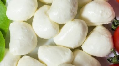 4K görüntü. mozzarella peyniri, fesleğen ve domates masaya uzanmış İtalya bayrağını sembolize ediyor. Kamera hareketi. Kamera masadan uzaklaşır..