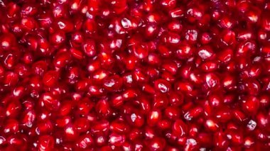 4K görüntü. Nar tohumlarından arkaplan. Kamera hareketi. Kamera arka plana yaklaşıyor. kırmızı tanecikler.