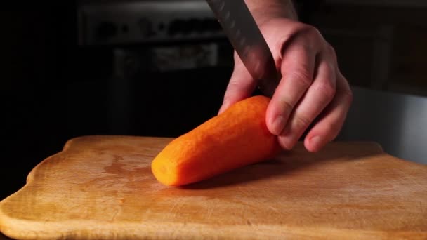 Wortelen Snijden Een Man Snijdt Een Wortel Twee Helften Koken — Stockvideo