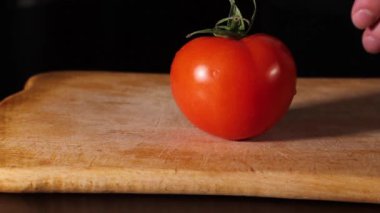 Bir adam domatesin yeşil kuyruğunu koparır. Şef domatesi soyar. yemek salatası.