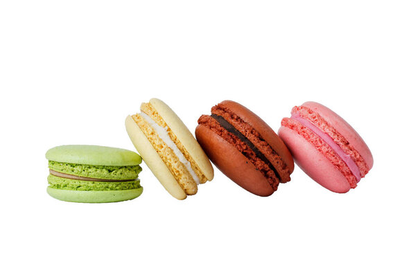 green, yellow, brown and pink macarons isolated on white. without a shadow.