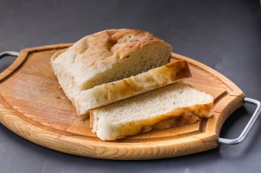 Eski ahşap tahta üzerinde ekmek dilimlenmiş.