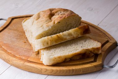 Eski ahşap tahta üzerinde ekmek dilimlenmiş.