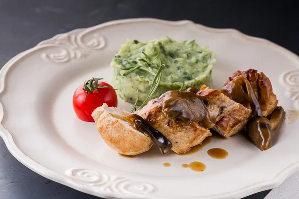 Куряче м'ясо з картопляним пюре на білому столі — стокове фото