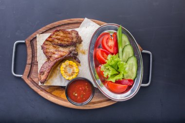 Ahşap plaka üzerinde sebze ile çeşitli lezzetli ızgara et