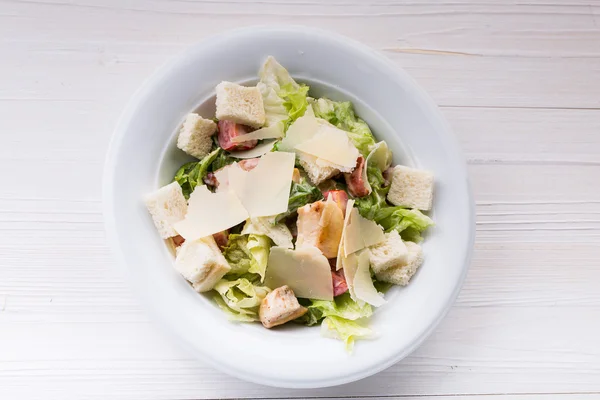 Salade César au poulet et légumes verts sur table en bois — Photo