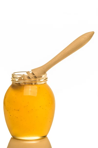 Glass jar of honey with wooden drizzler isolated on white backgr — Stock Photo, Image