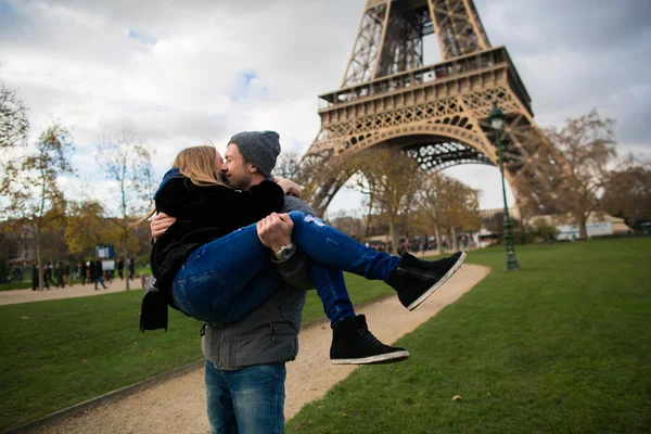 Glücklich lächelndes Paar küsst sich vor dem Eiffelturm in Paris — Stockfoto