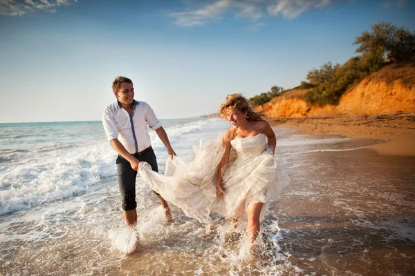 Couple running on a sandy beach — Stock Photo, Image