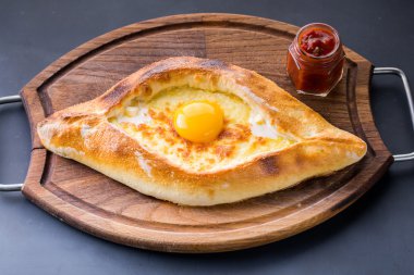 Çiğ yumurta ile karanlık tabloda Acaralı khachapuri yakın çekim