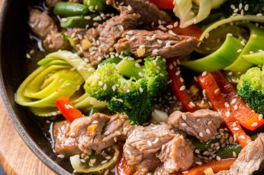 koyu arka plan üzerinde bir tavada sebze ile sığır eti güveç