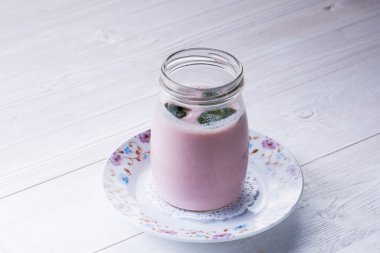 Beyaz tahta masada kavanoz yoğurt küçük cam ev yapımı