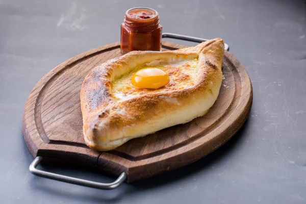 Acaralı khachapuri çiğ yumurta ile ahşap masa üzerinde kapat