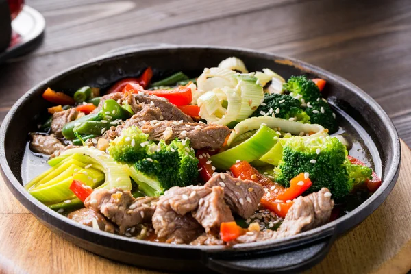 Beef stew with vegetables in a frying pan over dark background — Stock Image Beef stew with vegetables in a frying pan over dark background Stock Image