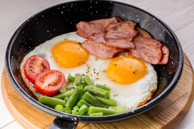 Sahanda yumurta domates ve kuşkonmaz eşliğinde bir Pan