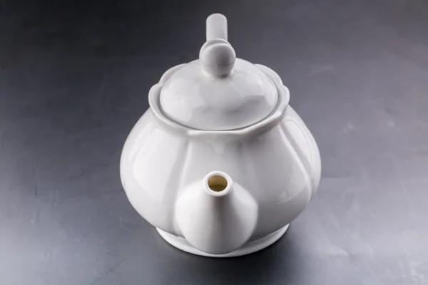 Чайник и чашка чая на темном фоне — стоковое фото