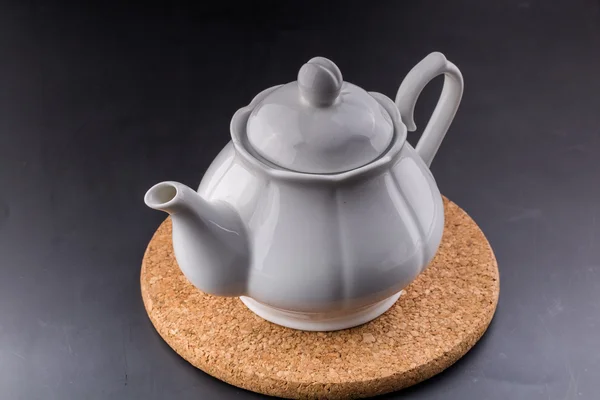 Чайник и чашка чая на темном фоне — стоковое фото