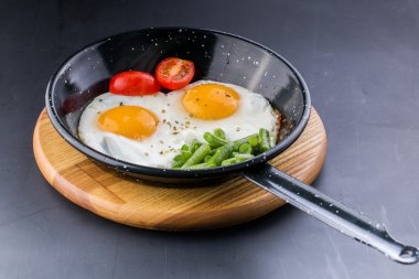 Sahanda yumurta domates ve kuşkonmaz eşliğinde bir Pan