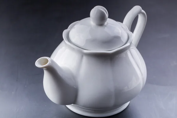 Tetera y taza de té sobre fondo oscuro — Foto de Stock