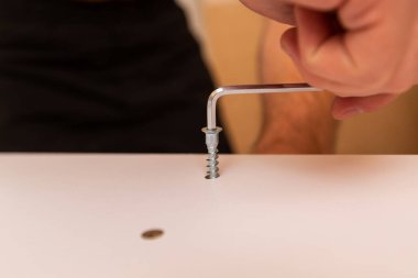 Sihirli anahtarla çip tahtasına vida takmak, inşaatçının elleri.