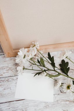 Metin için beyaz çarşaf ve açık ahşap arka planda beyaz çiçekli yeni bir dal