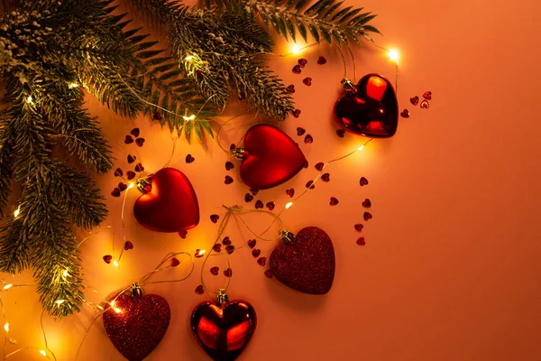 Sfondo di Natale con cuori giocattolo rosso e una ghirlanda luminosa — Foto Stock