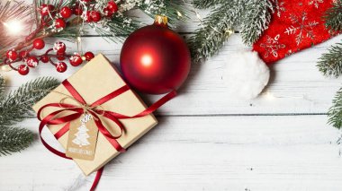 Hediyesi olan bir Noel düzlüğü ve parlak ahşap arka planda yeni yıl oyuncakları.. 