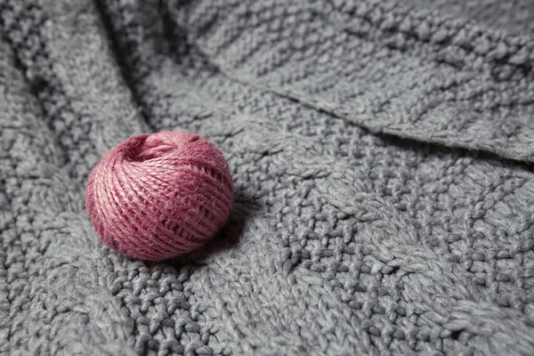 Boll av rosa ull på en stickad grå tröja — Stockfoto