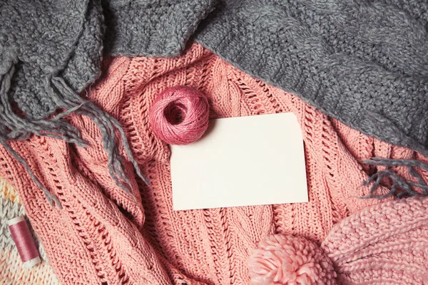 Bola de lã rosa com cartão branco para texto sobre fundo de malha rosa e cinza — Fotografia de Stock