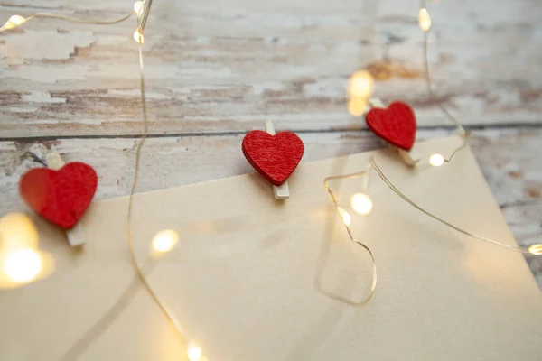 White card for text with red hearts-clothespins on a wooden background. valentines day concept — Stock Photo, Image