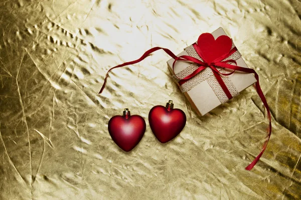 Cuori rossi con confezione regalo su sfondo dorato. giorno di San Valentino — Foto Stock