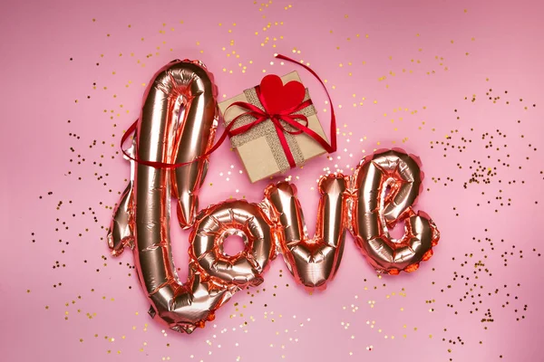 핑크 배경에 있는 선물 상자에 사랑이라는 황금 단어 — 스톡 사진