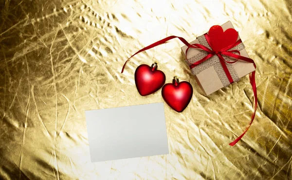 Cuori rossi con confezione regalo su sfondo dorato. giorno di San Valentino — Foto Stock